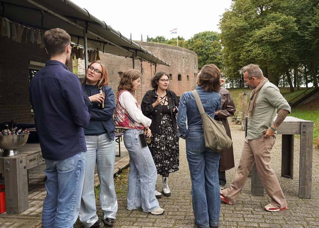 Deelnemers event zijn met elkaar in gesprek tijdens borrel buiten fort