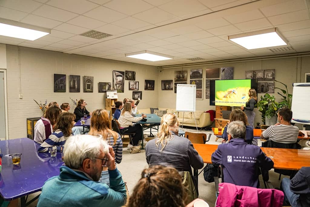 Deelnemers in de zaal kijken naar de slide Insecten helpen zin of onzin?