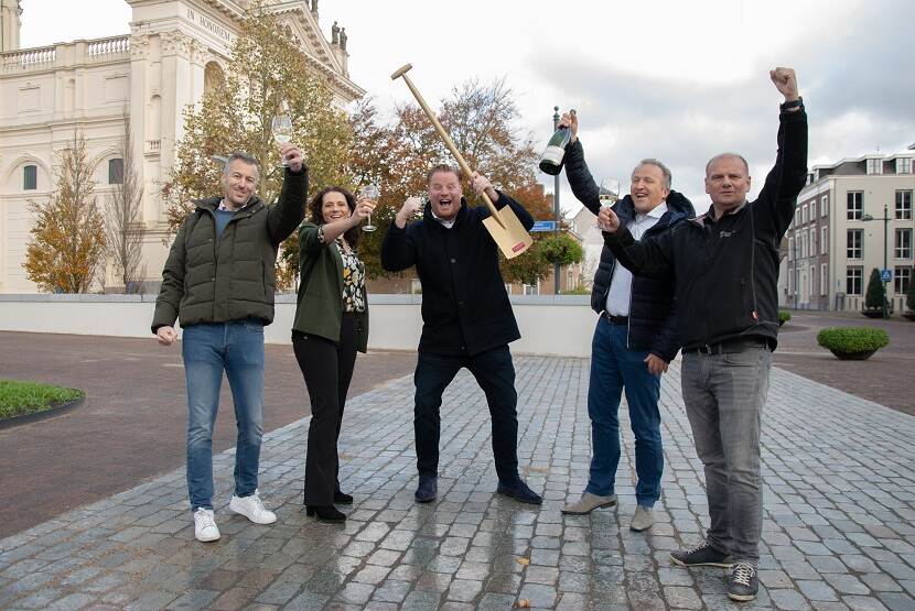 Medewerkers gemeente Halderberge met gouden schep en champagne bij het gemeentehuis